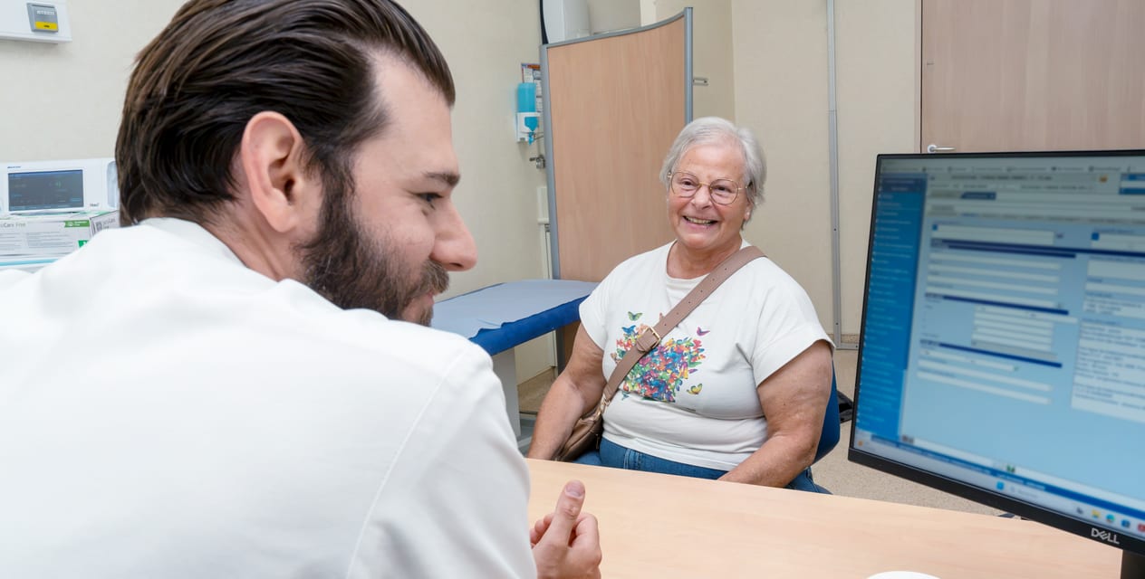 Une patiente souriante en consultation face à un médecin de Gustave Roussy.