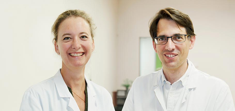 Une chercheuse et un chercheur de Gustave Roussy souriants en blouse blanche.
